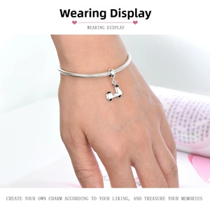 Close-up of S925 silver snake chain bracelet with white scooter enamel charm on wrist