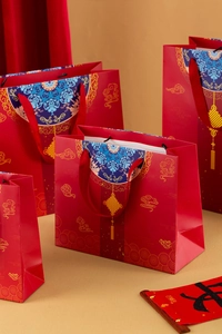 Detailed view of red paper gift bags with traditional Chinese gold and blue cloud patterns