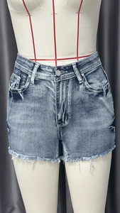 Detailed view of high-waisted vintage washed denim shorts with raw hem and metal button