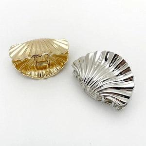Metallic shell hair claws in gold and silver finish with textured punk aesthetic