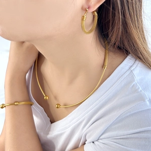 Detail of gold jewelry set showing mesh texture on necklace, bracelet, and earrings