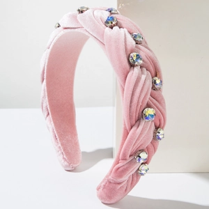 Close-up of pink velvet braided headband with sparkling colorful rhinestones