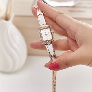 Elegant rose gold and white ceramic quartz watch with diamond bezel on rectangular dial