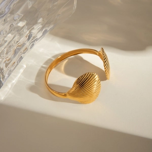 Retro 18k gold stainless steel open bangle with scallop shell design on geometric background