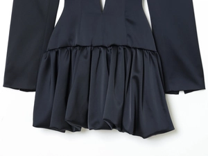 Détail d'une robe en satin noir à taille haute avec ourlet ballon élégant