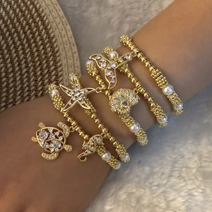 Ocean theme multilayer gold beaded bracelet with sea turtle, starfish, and fish tail charms