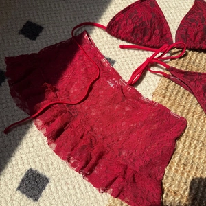 Vue détaillée du tissu en dentelle crochetée rouge d'un ensemble bikini de plage