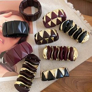 Close-up of geometric resin stretch bracelets with gold metal accents in various colors