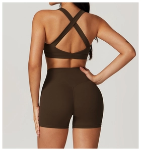 Dettaglio completo yoga marrone scuro con reggiseno sportivo incrociato e pantaloncini