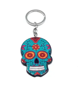 Detail of blue sugar skull keychain with pink floral patterns and metal ring