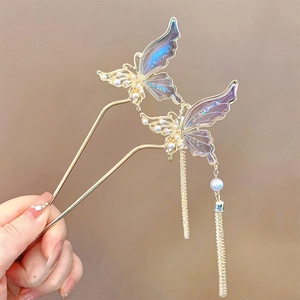 Détail du pic à cheveux papillon doré avec ailes dégradées et longs glands en perles