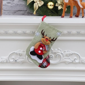 Detail of green linen Christmas stocking featuring a 3D reindeer and red plaid accents