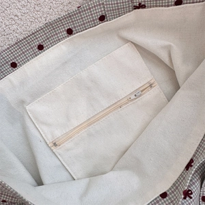 Vue détaillée de l'intérieur du sac en toile avec poche zippée et motifs à pois rouges