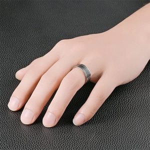 Anillo de acero de titanio con diseño trenzado y bordes pulidos en el dedo