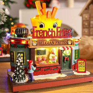 Close-up of lighted French Fries shop miniature with warm LED glow and festive details