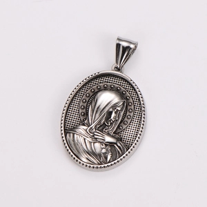 Close-up of vintage silver oval pendant featuring a detailed Virgin Mary relief carving