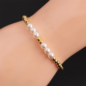Elegant gold-plated beads and white pearls elastic bracelet on a model wrist
