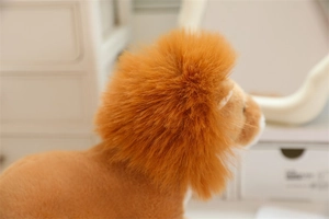 Close-up of the plush lion doll showing dense orange mane and soft yellow fur details