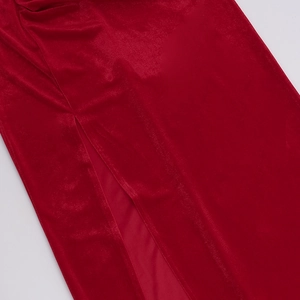 Close-up of elegant red velvet dress showing high-slit cut and soft fabric texture