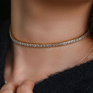Gros plan d'un collier tennis doré avec cristaux de zircone carrés sur le cou