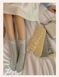Detailed view of blue polka dot socks with ruffled edges and delicate ribbon bows