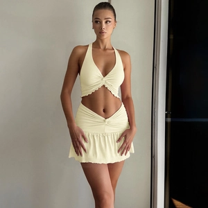 Detailed view of women's halter crop top and ruched mini skirt in pale beige knit fabric