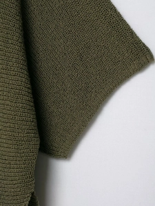 Close-up detail of olive green knit top showing fine crochet texture and quality fabric