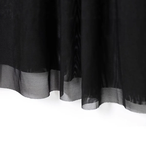 Gros plan sur le tissu en tulle noir d'une robe tube avec une texture de filet fine