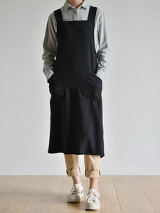 Full view of black washed linen apron with two front pockets and minimalist design