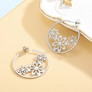Silver stainless steel hoop earrings featuring hollow daisy patterns on a two-tone background