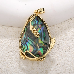 Gros plan détaillé du pendentif goutte en nacre d'abalone dorée avec motifs de feuilles