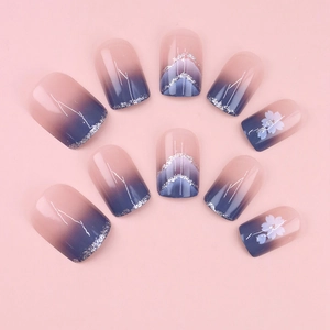 Blue gradient press-on nails with delicate cherry blossom designs and silver glitter accents