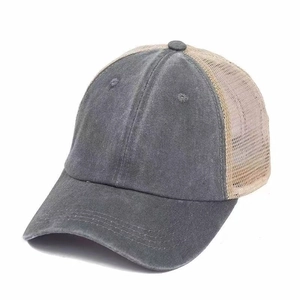 Detailed macro view of the breathable mesh fabric and vintage washed cotton on trucker hat