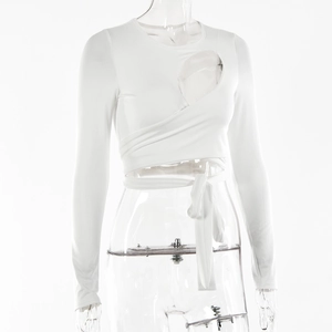 Detail eines weißen Langarm-Crop-Tops mit gekreuzten Taillenbändern und Cut-out-Design vorne