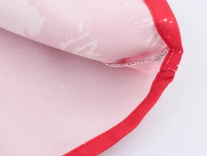 Detailed close-up of red contrast piping and stitching on pink coconut tree fabric