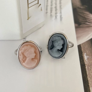 Vintage 925 silver cameo portrait rings with pink and grey oval stones on a magazine