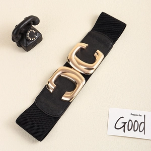 Detailed view of polished golden C-shaped metal buckle on a black elastic waist belt