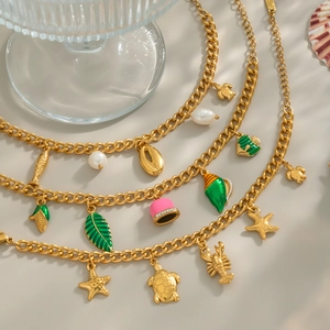 Collana a strati in oro 18K con perla, stella marina e tartaruga per un look estivo