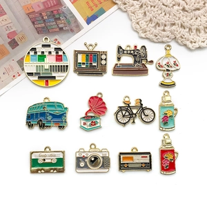 Flat lay of vintage enamel pendants featuring sewing machine, camera and bicycle charms