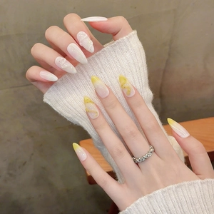 Faux ongles stiletto faits main avec dégradé marbré jaune et blanc et détails en relief