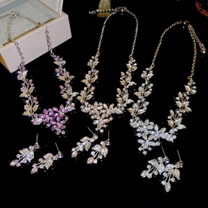 Detail view of flower pendant necklaces and earrings in purple, champagne and silver
