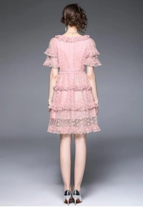 Detail of pink lace dress back with tiered ruffled skirt and intricate floral embroidery