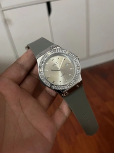 Macro shot of silver quartz watch featuring rhinestone bezel and grey silicone strap