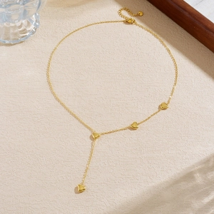 Elegant gold Y-shaped necklace with multiple heart pendants on a minimalist chain