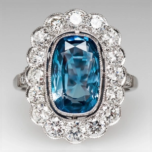 Luxury cushion-cut blue gemstone ring with double halo diamond setting and milgrain edge