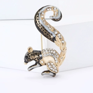 Detailed close-up of a golden squirrel brooch with enamel finish and sparkling crystals