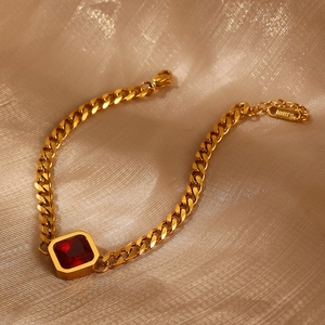 Detailansicht eines goldenen Gliederarmbands mit einem quadratischen roten Zirkonia-Stein