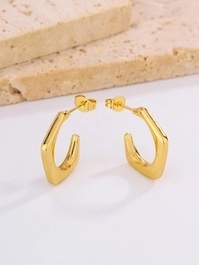 Macro detail of minimalist oval egg-shaped gold-plated stainless steel hoop earrings