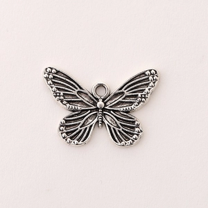 Detailed view of silver butterfly charm with vintage textures and top hanging ring