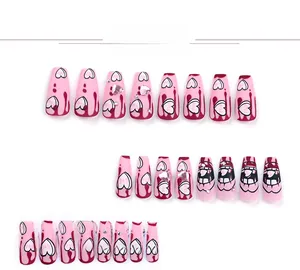 Detail shot of pink matte press-on nails with fluid heart patterns and rhinestone accents